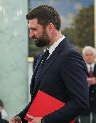 Nikodem Rachoń, polski filozof i menedżer, w dynamicznej pozie, na tle symbolizującym jego różnorodną karierę zawodową.