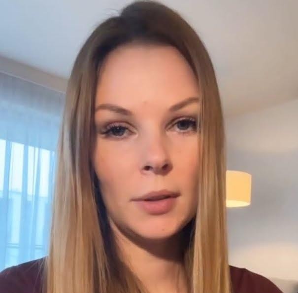 Małgorzata Tomaszewska w swobodnej pozie w swoim domu w Warszawie, w tle widoczne elementy miejskiego krajobrazu.