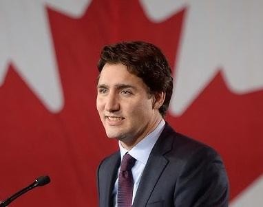 Justin Trudeau w mniej formalnym otoczeniu, uśmiechnięty, interakcja z ludźmi, dostępność.