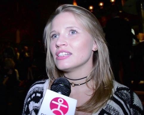 Natalia Rybicka w dynamicznej pozie tanecznej, ujęta w ruchu, na tle rozmytego studia tanecznego lub sceny.