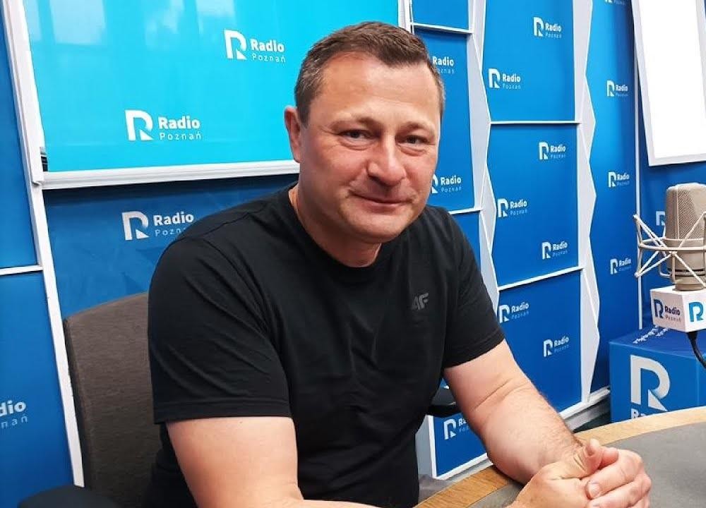 Krzysztof Paszyk podczas wystąpienia publicznego lub obrad parlamentarnych, z gestykulacją, w tle rozmyte ławy poselskie lub audytorium.