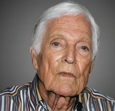 Richard Chamberlain na scenie teatralnej, pełen pasji podczas występu, otoczony elementami scenografii.