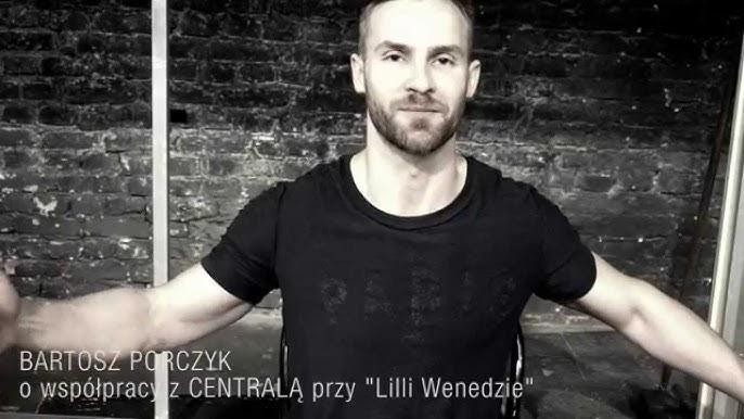 Bartosz Porczyk w zamyślonej pozie, z delikatnym światłem podkreślającym rysy twarzy, na niewyraźnym tle sugerującym scenę teatralną.