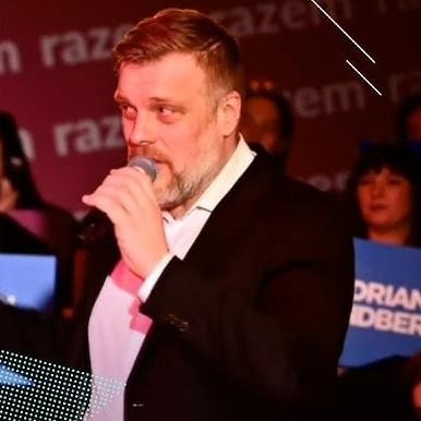 Adrian Zandberg podczas wystąpienia publicznego, z pasją przemawiający do zgromadzonych.