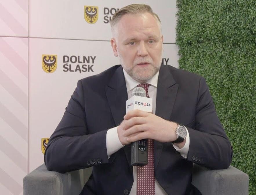 Dawid Jackiewicz podczas wystąpienia publicznego, z gestykulacją i zaangażowaniem, na tle wydarzenia politycznego.