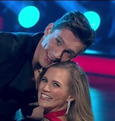 Agnieszka Kaczorowska w dynamicznej pozie na parkiecie, ukazująca jej talent taneczny i artystyczny.