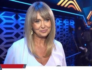 Ewa Wachowicz na szczycie góry, w stroju trekkingowym, uśmiechnięta, z malowniczym krajobrazem górskim w tle, symbolizującym jej pasję do wspinaczki i zdobywania kolejnych wyzwań.