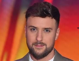 Aleksander Tomasz Sikora, prezenter telewizyjny, w swobodnej interakcji na planie telewizyjnym, uchwycony zza kulis.
