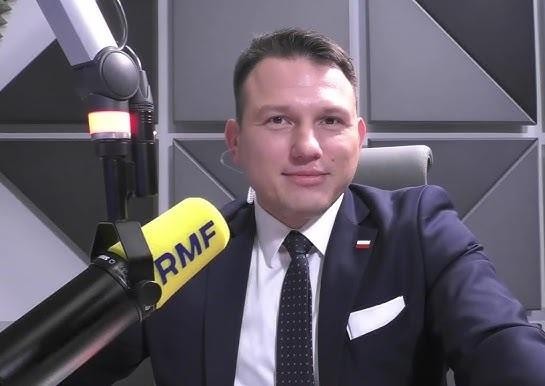 Sławomir Mentzen przemawiający z energią do tłumu na wiecu politycznym, z widocznym zaangażowaniem słuchaczy.