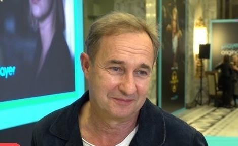 Marek Kalita w swoim domu w Puszczy Kampinoskiej, zamyślony, w otoczeniu natury, symbolizujący spokój i prywatność.