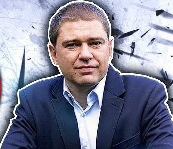 Piotr Szumlewicz podczas wystąpienia publicznego lub spotkania związkowego, aktywnie gestykulujący, w tle zamazana publiczność.