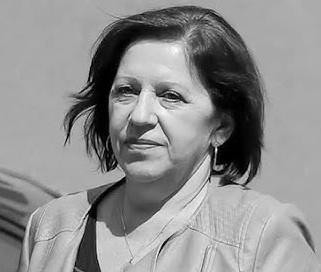 Barbara Skrzypek w tle formalnego otoczenia, sugerującego przesłuchanie lub sąd, z wyrazem dyskrecji i powagi.