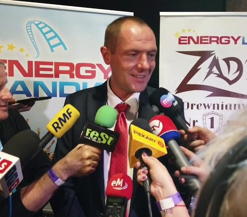 Dynamiczny widok z góry na park rozrywki Energylandia, ukazujący różnorodne atrakcje i tętniący życiem tłum, symbolizujący sukces biznesowy Marka Goczała.