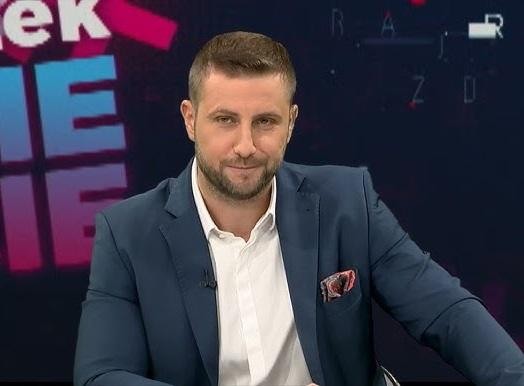 Miłosz Kłeczek podczas ożywionej dyskusji w studiu telewizyjnym.